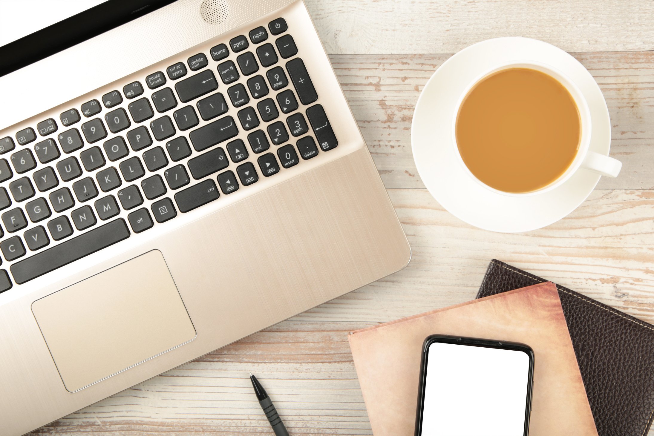 Laptop and coffee cup on wood table. View from above